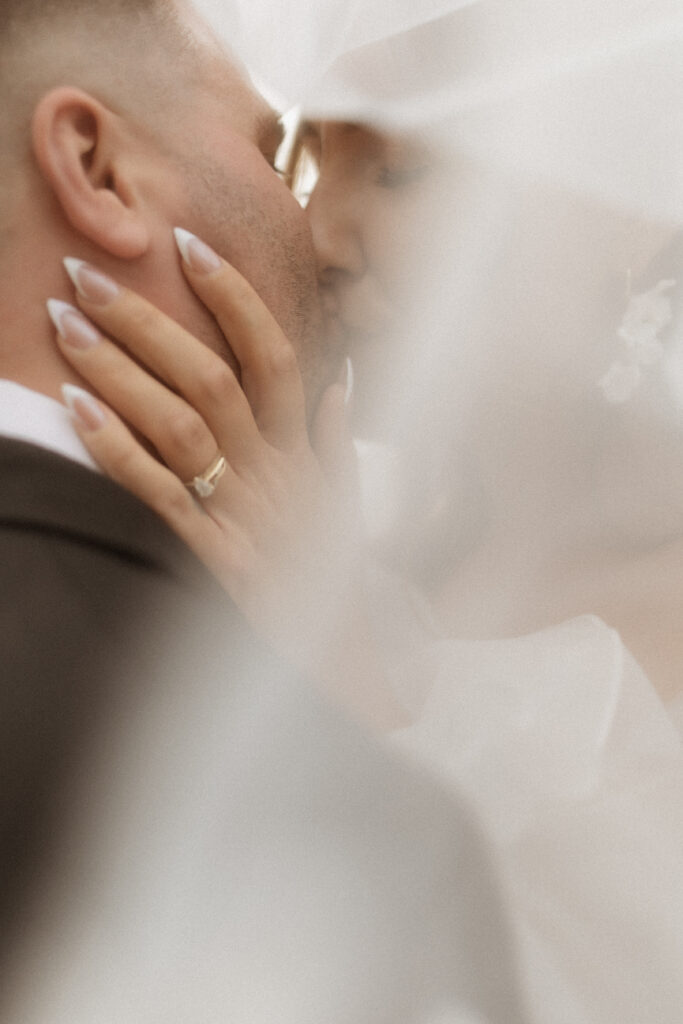 Playful moment of bride and groom running along prairie path captured in Canada”

“Romantic Saskatchewan wedding portraits with floral lace gown and wind-swept veil”
