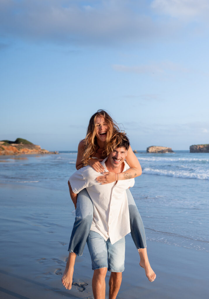 Playful anniversary photos splashing in the ocean on the Menorca coastline
Romantic couple portrait with waves and open sky in Menorca, Spain