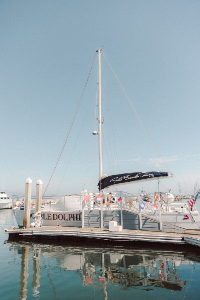 Sailboat docked in Santa Barbara Harbor for a wedding-day sailing experience, with a clear blue sky and calm water.