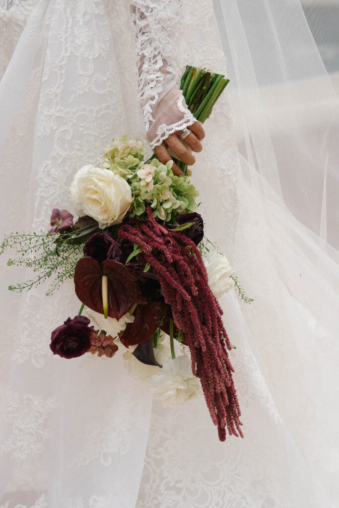 Burgundy wedding bouquet with pops of white and green
"Lush floral centerpiece champagne roses wedding reception tablescape"