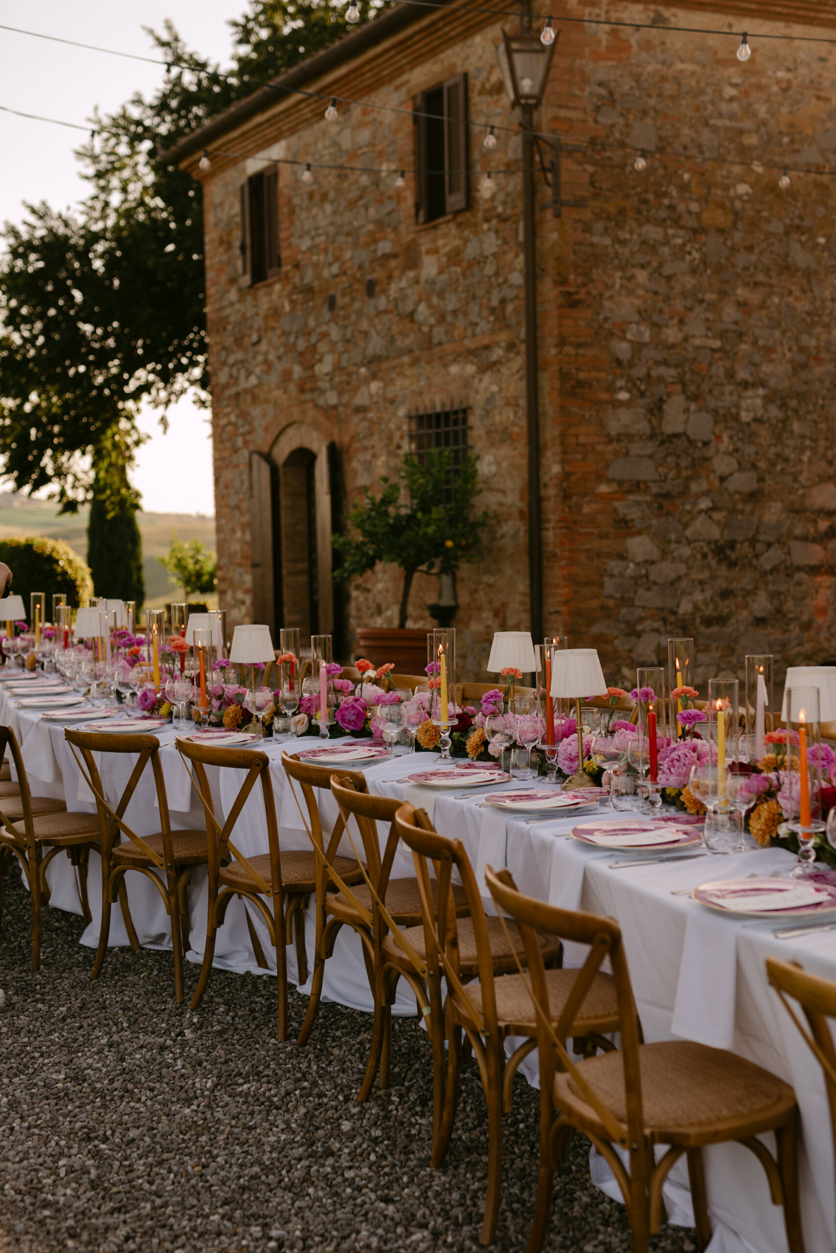 Long candlelit reception table with pink peonies and Ginori 1735 place settings at Villa Boscarello, luxury Tuscany wedding