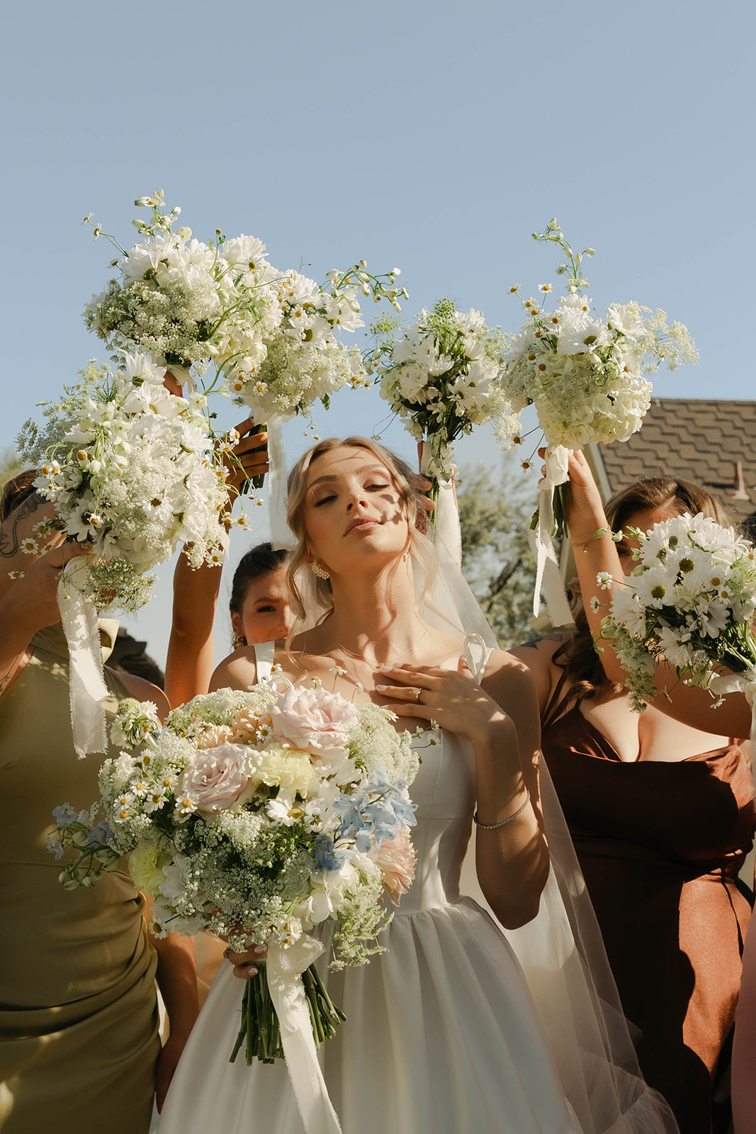 Bride and bridesmaids raising their bouquets