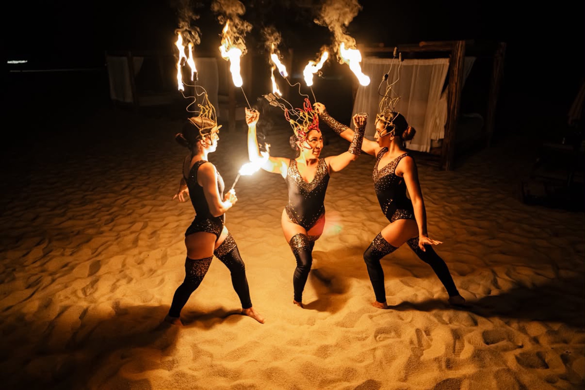 Fire dancers performing on the beach at night