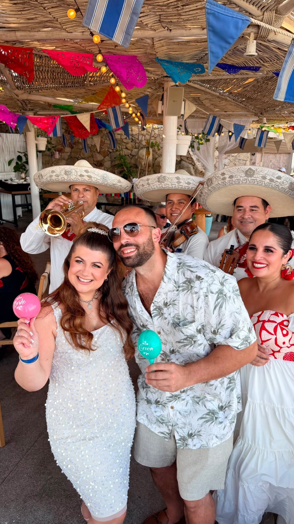 The couple with a mariachi band and folk dancers at the fiesta