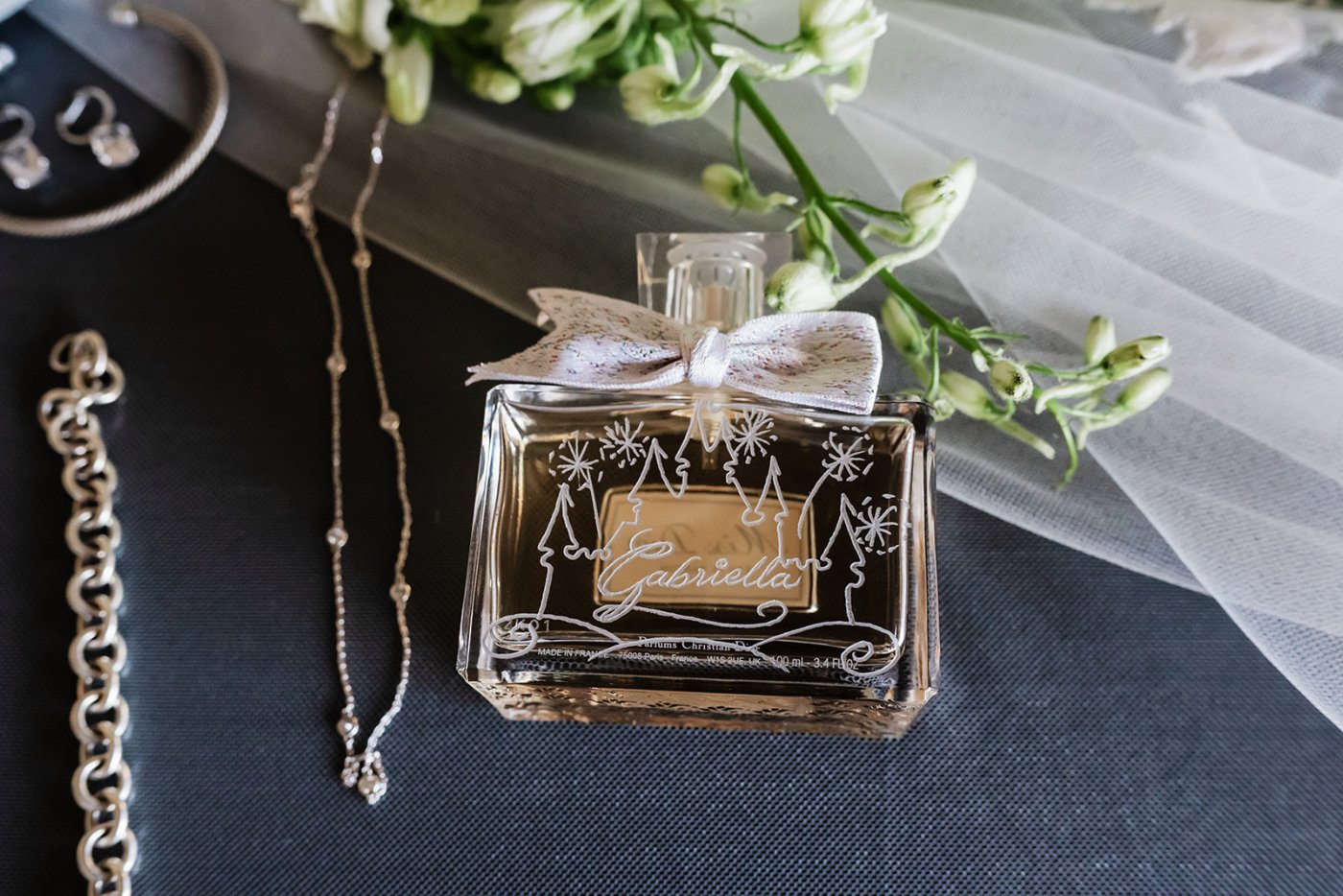 Perfume and rings with florals and veil