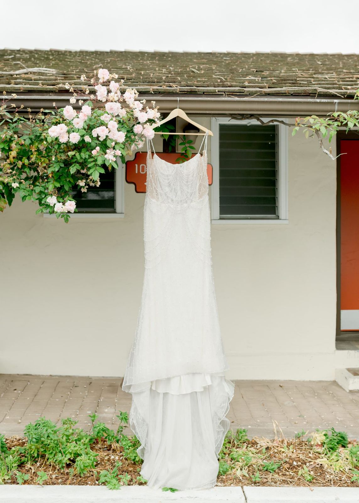 Beaded wedding dress hanging before a Monterey wedding