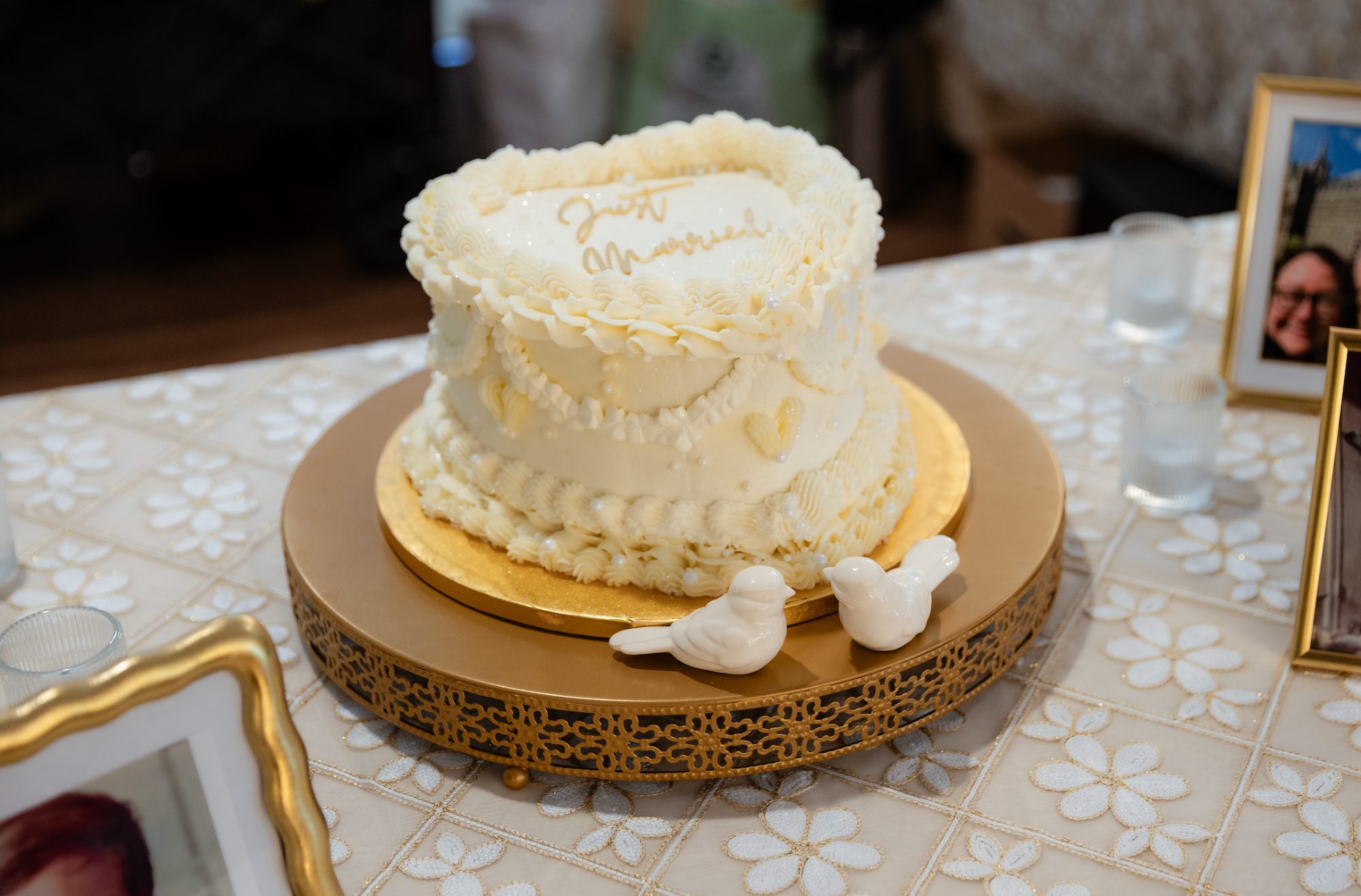 Vintage piped heart shaped wedding cake with Just Married script and ceramic love birds