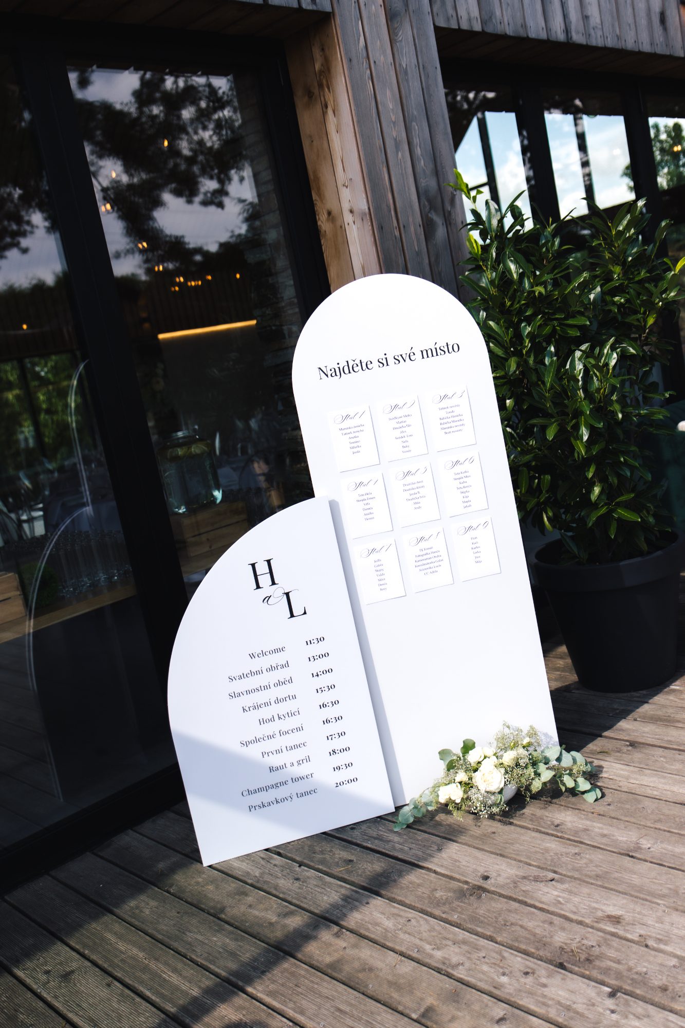 White arched welcome and seating sign with the couple’s monogram at a Czech Republic wedding