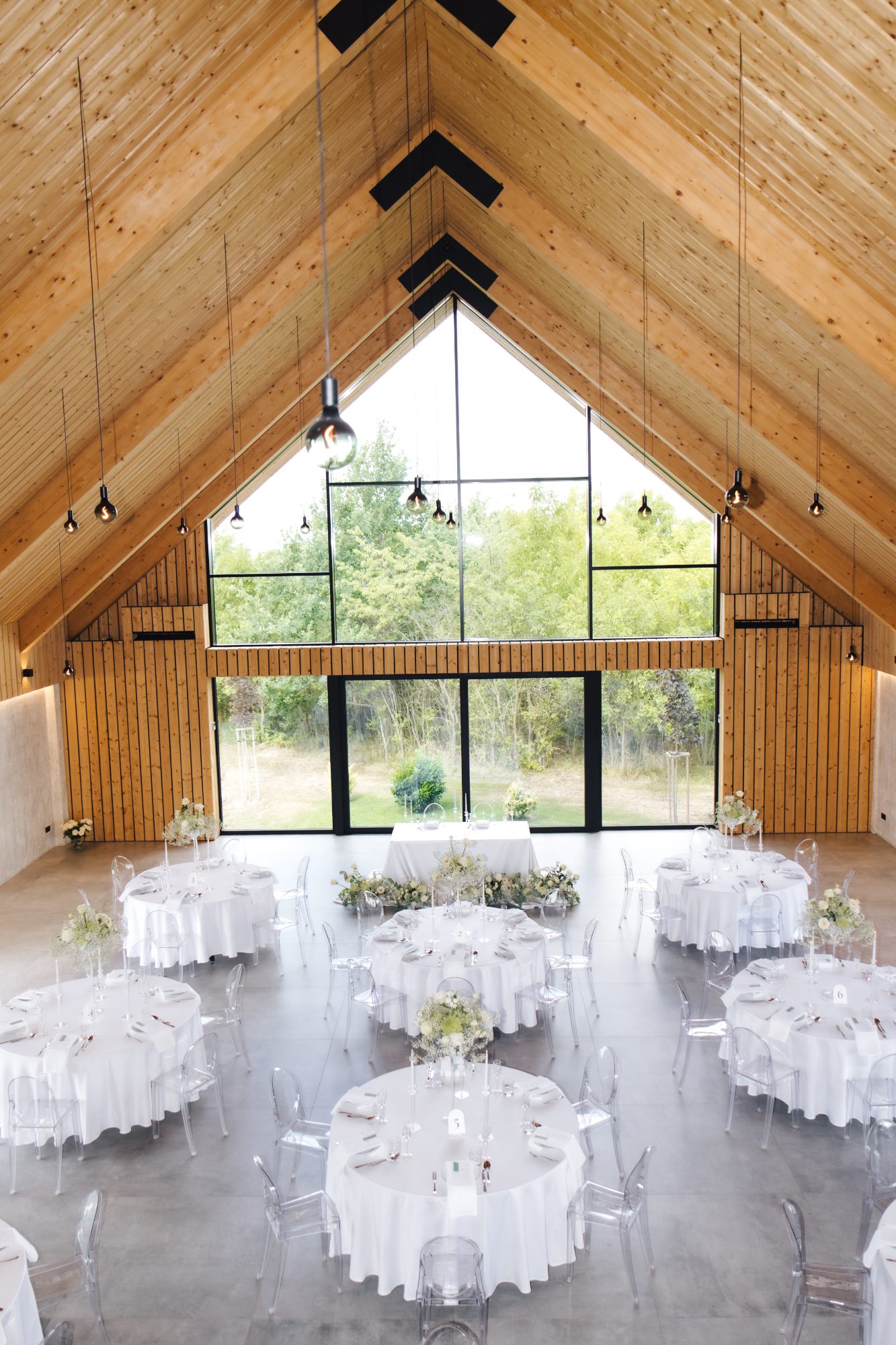 Reception tables set in white and green under the A frame at this Czech Republic wedding